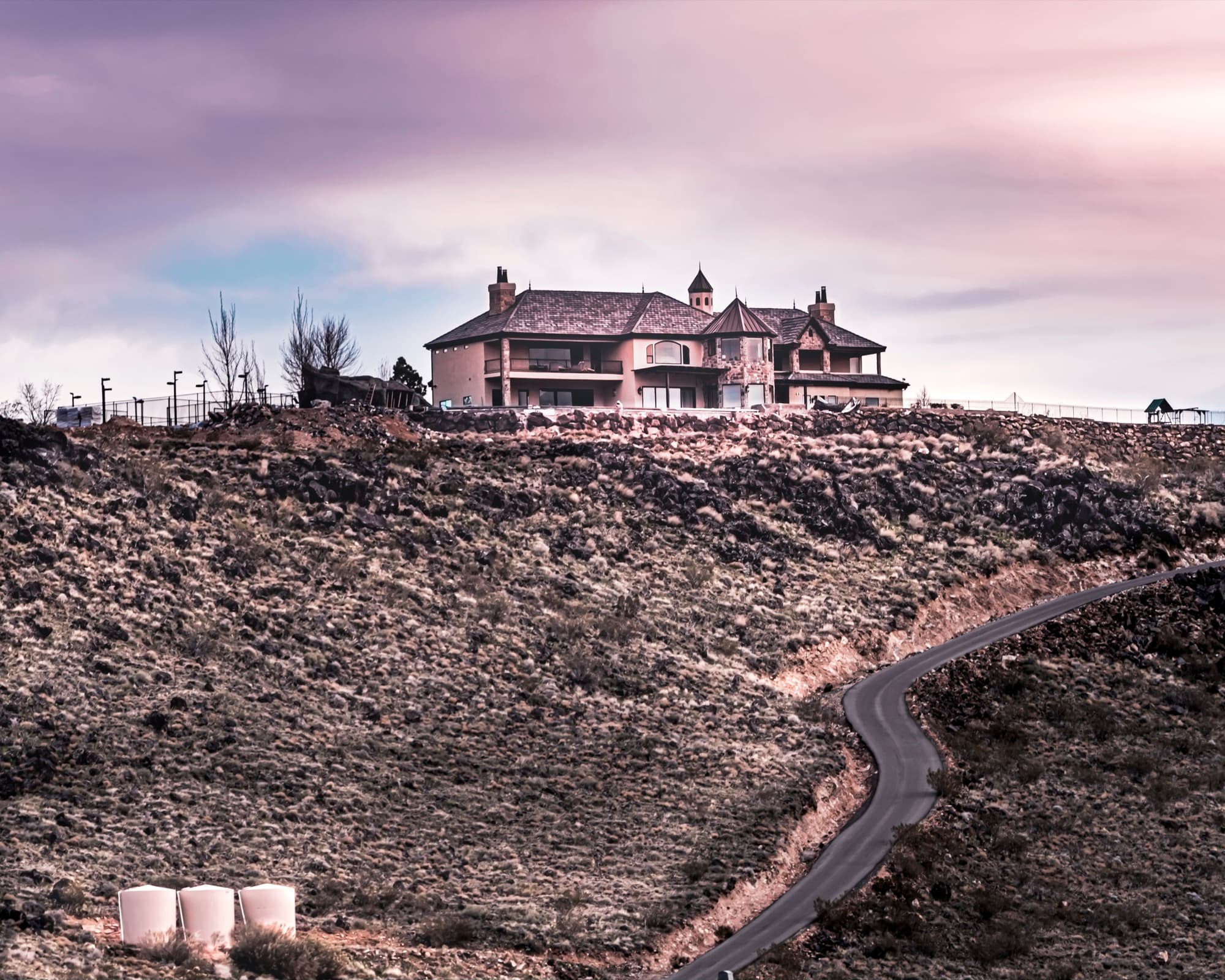 The Ridgeline House alone on the lava mesa above Sand Hollow, the road Nielson Development built winding up to it