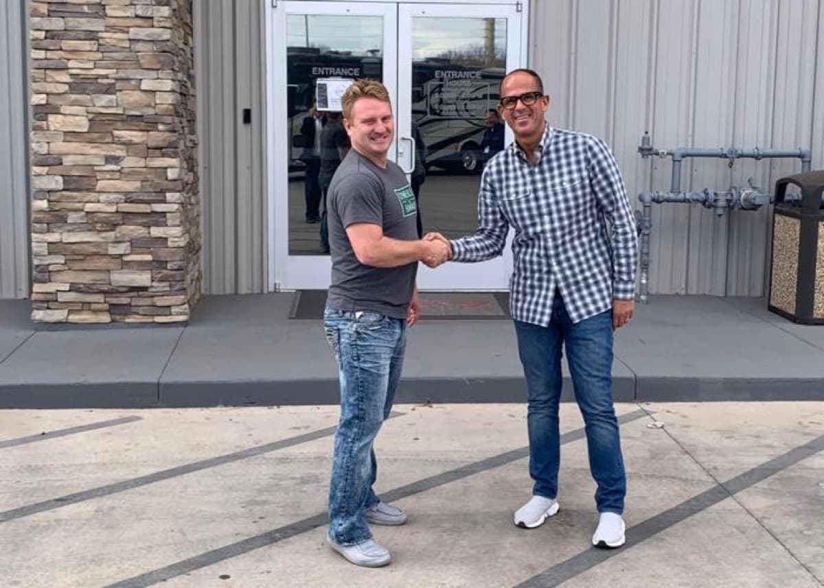 Scott Nielson shaking hands with Camping World CEO Marcus Lemonis outside the Nielson RV dealership